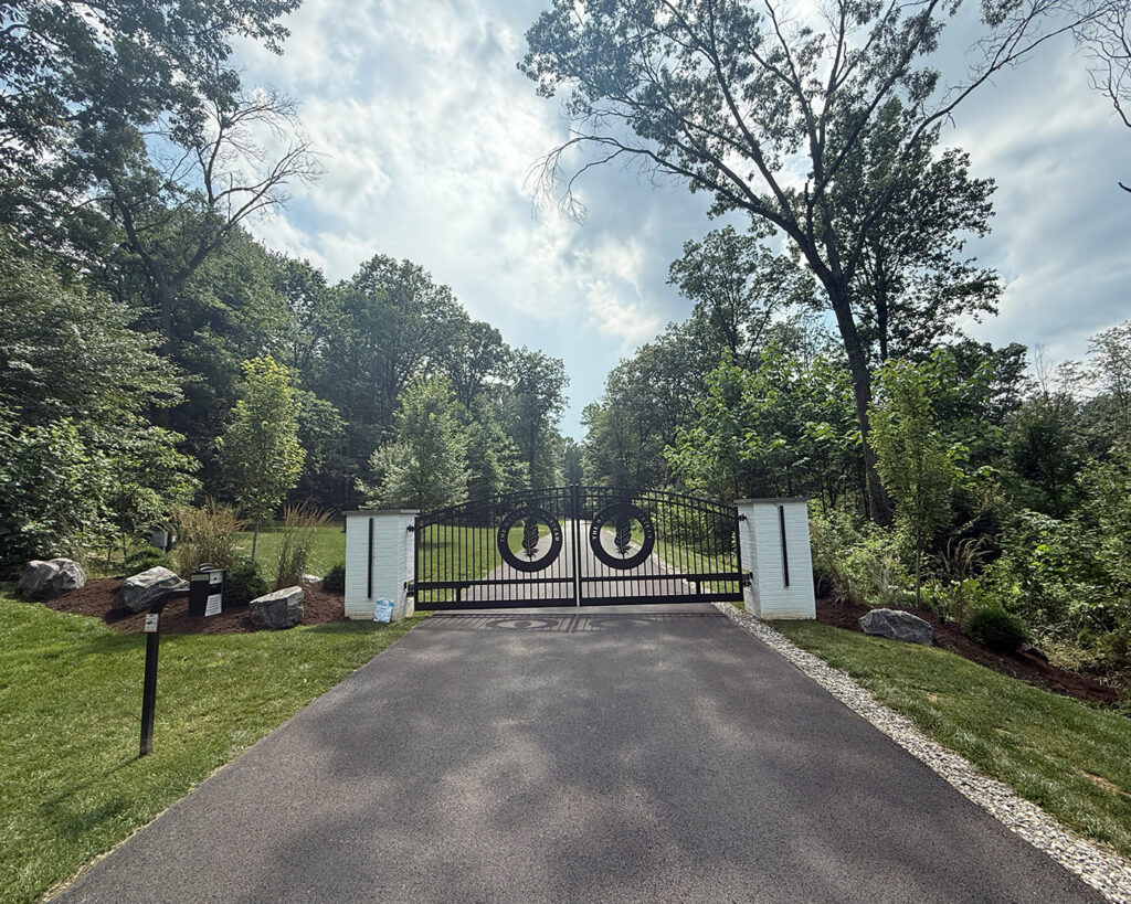 Wide view of entrance gate with surrounding perennial plantings at a modern farmhouse landscape in Christiana, Pennsylvania