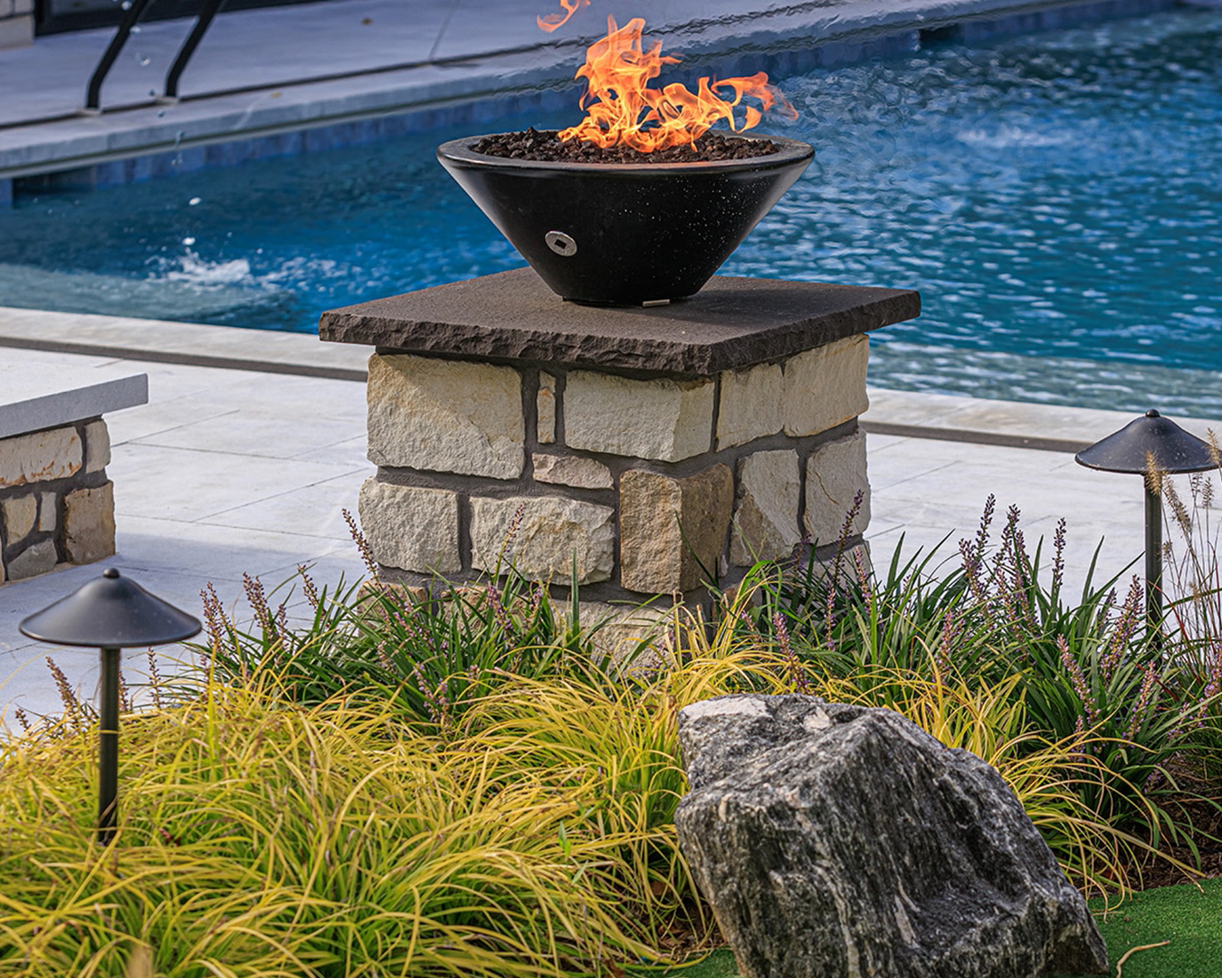 Close-up view of putting green with surrounding perennial plantings and cobblestone edging at a modern farmhouse landscape in Christiana, Pennsylvania